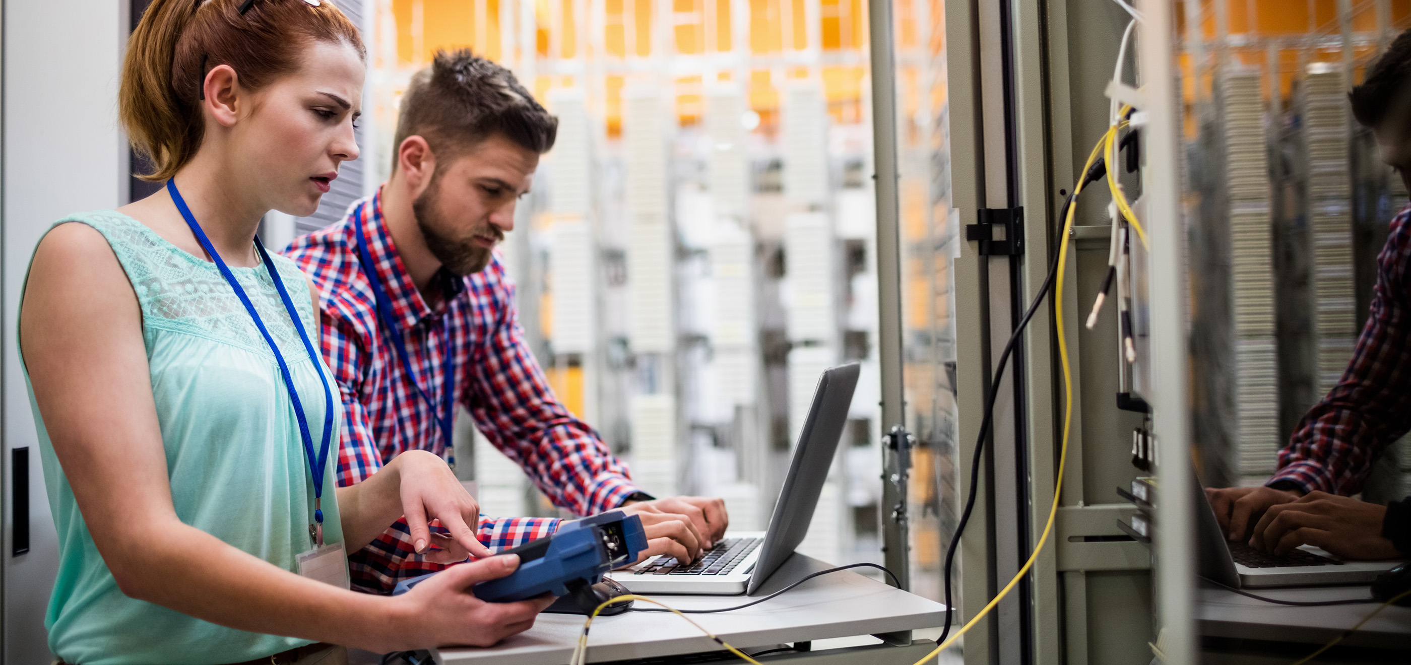 two coworkers in a data center working on a problem