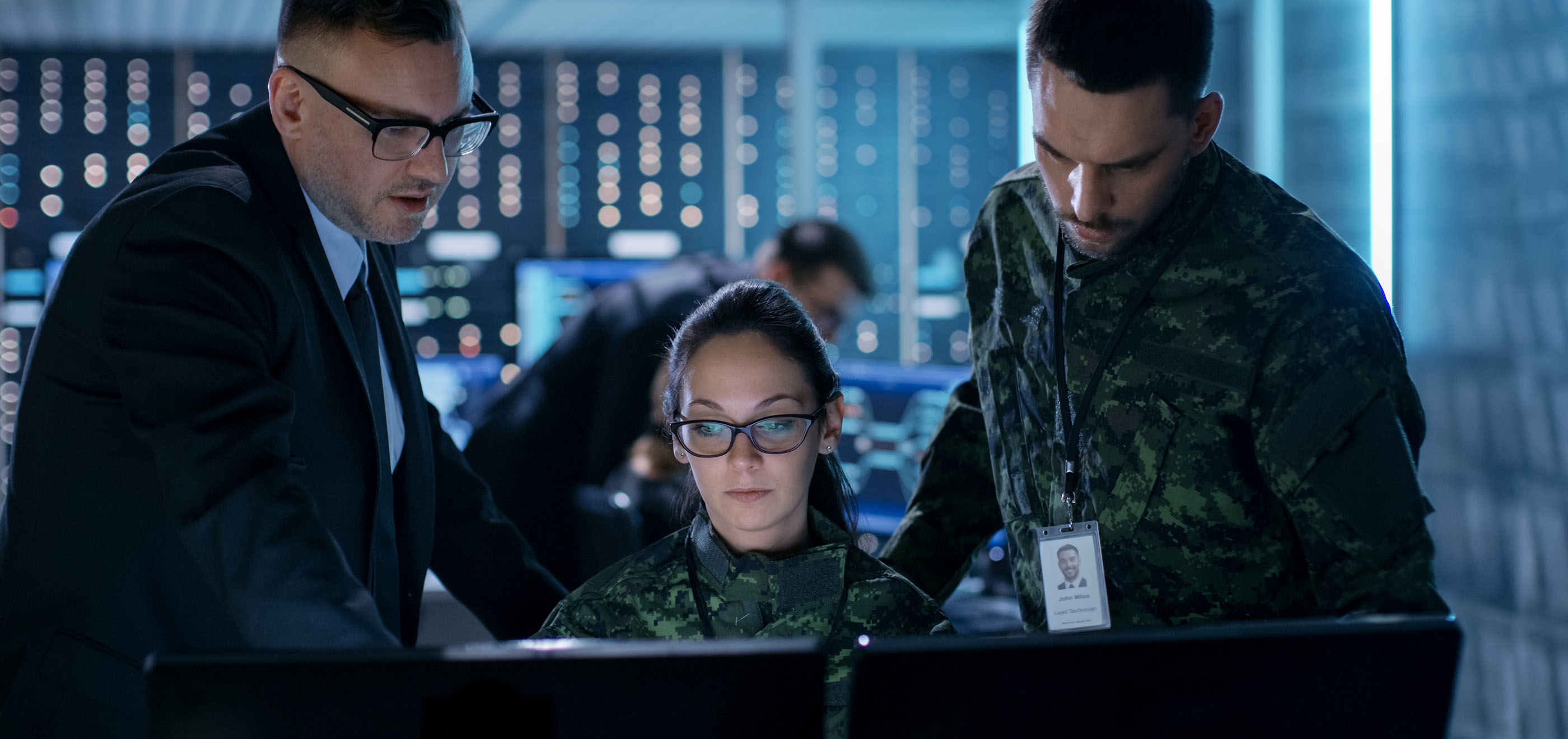 two coworkers in military uniforms working on computer