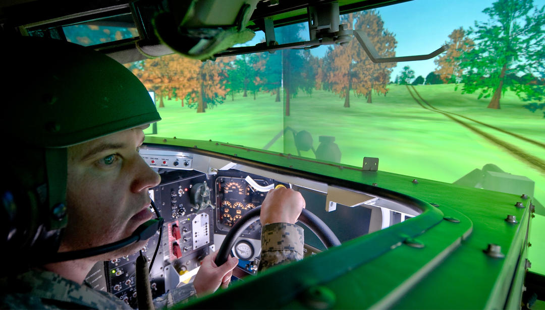 solider in a simulator driving a tank