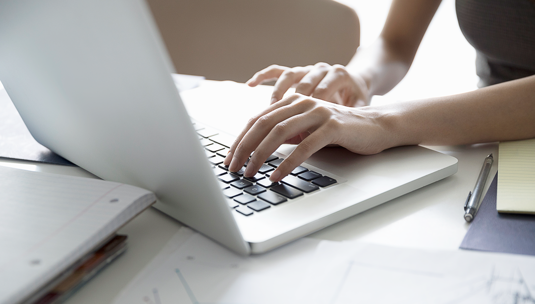 hands typing on laptop keyboard