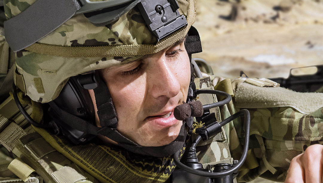 man in military uniform in the field with helmet on