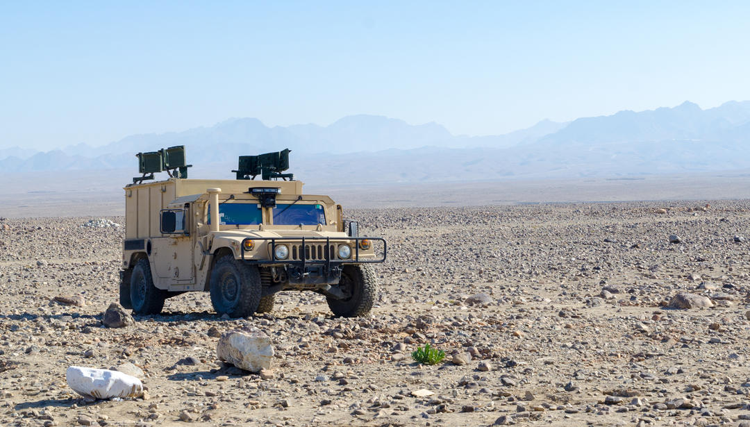 military humvee parked in a desert in afghanistan