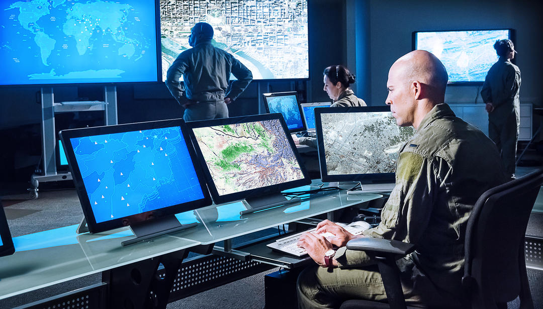Man looking at computer screen in a command center