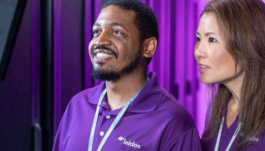 Two Leidos Employees in purple shirts
