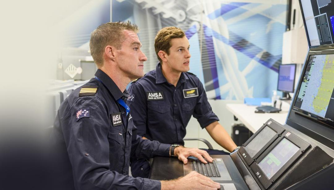 two men working at control panel with uniforms on