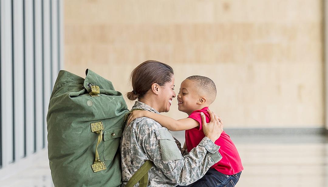 woman in uniform holding son