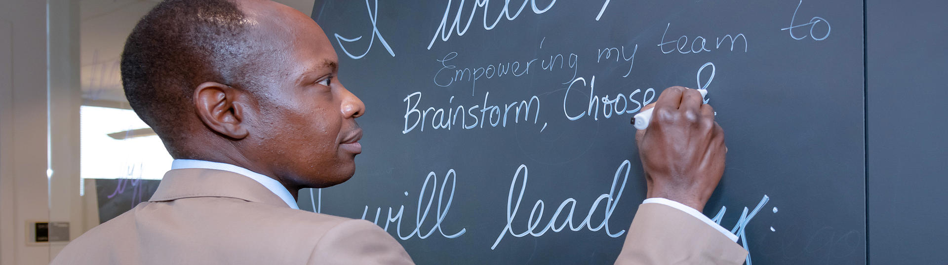 CHRO Paul Engola writes a message at the Women's Leadership Forum