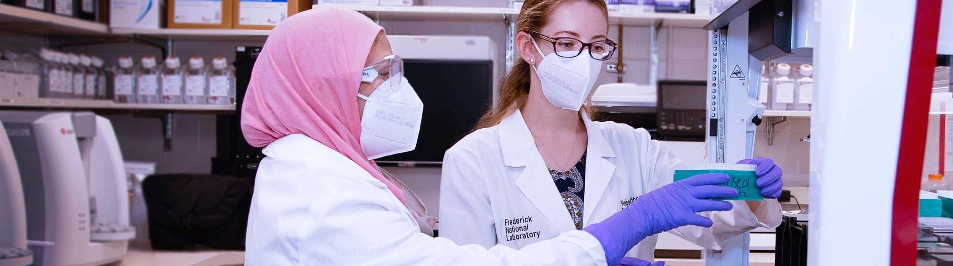 Two female scientists conducting working inside the Fredrick National Laboratory