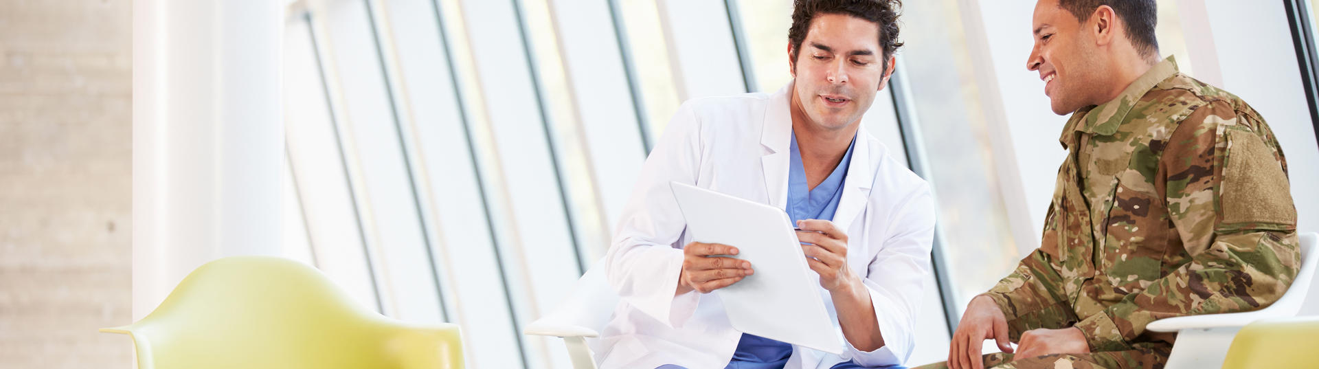 doctor speaking with service member while looking at document