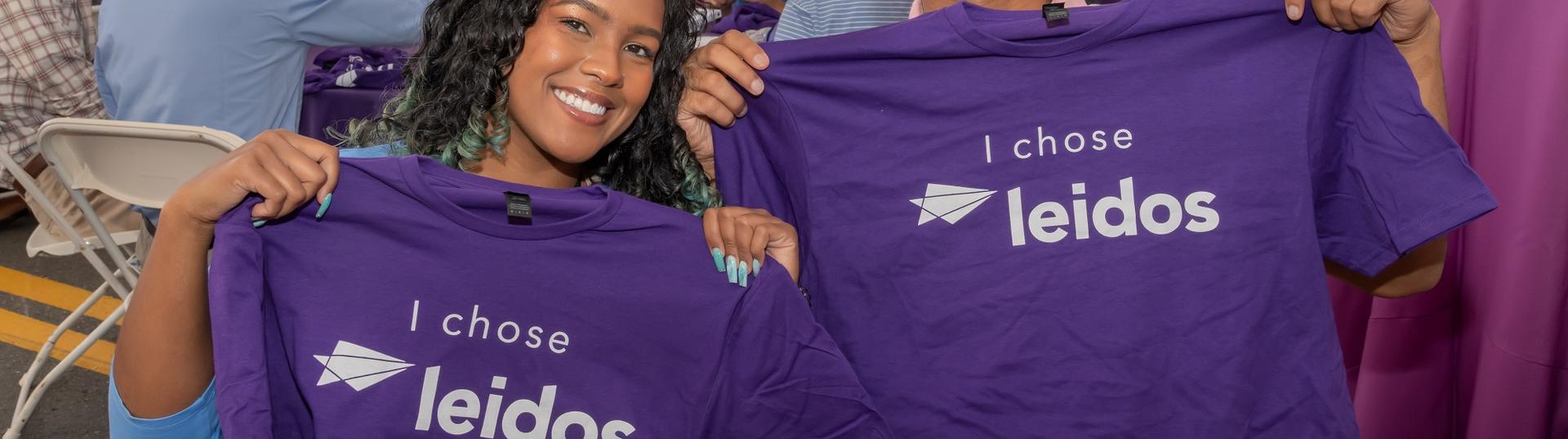 Picture of two interns holding tshirts