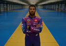 NASCAR Driver Bubba Wallace in Leidos racing suit standing in an empty garage with arms crossed