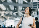 A woman at the airport, looking up at something hanging in the air