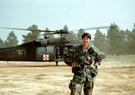 Nanette Patton in the desert with a helicopter behind her