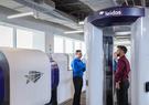 man standing in scanning tube at airport