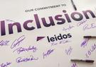 A poster with the word "inclusion" signed by several Leidos employees