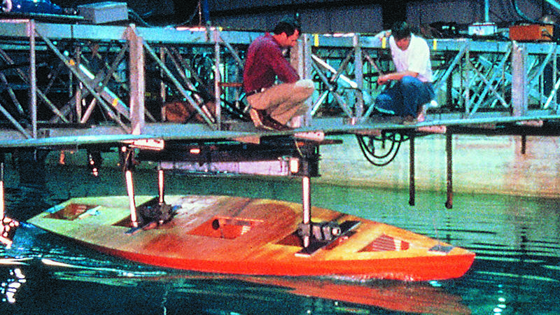 two scientists working on a yacht prototype in a swimming pool