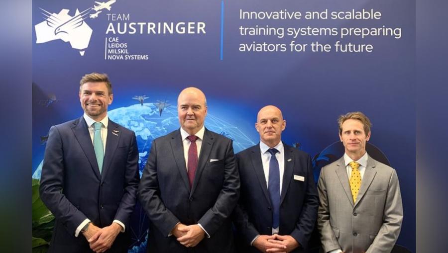 Four men standing in front of AUStringer poster