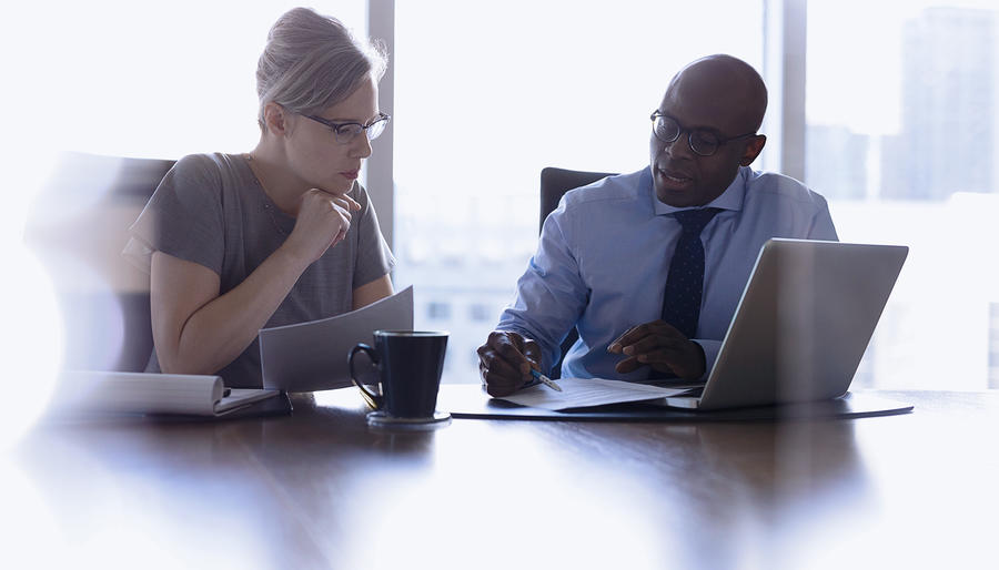 Lawyers reviewing contracts at a laptop