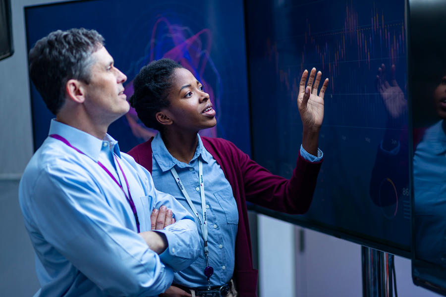 Leidos employees looking at large monitors
