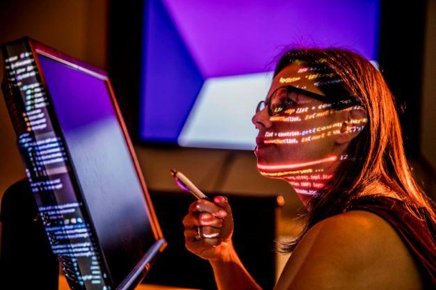 Woman looking at computer screen with writing projected on her