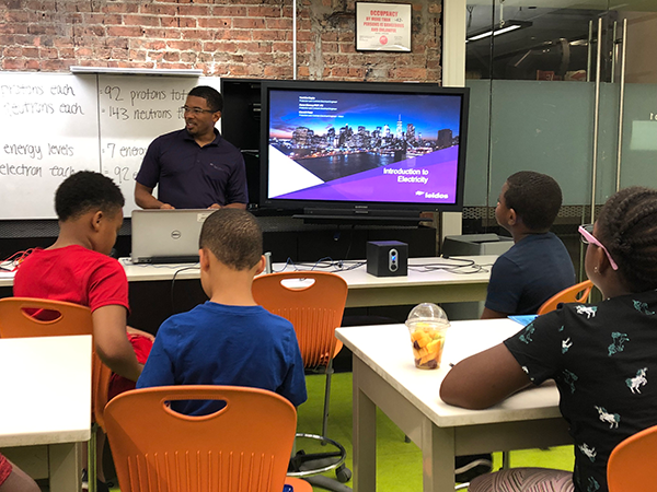 Aaron Dorsey mentoring group of kids in classroom