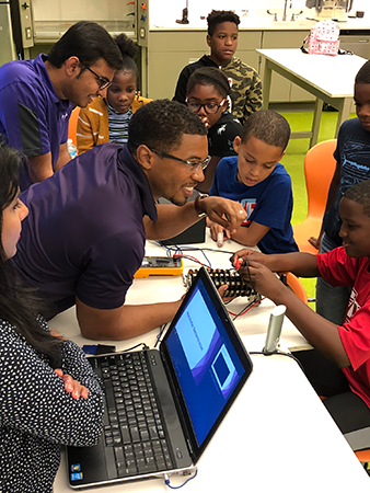Aaron Dorsey teaching programming to group of kids