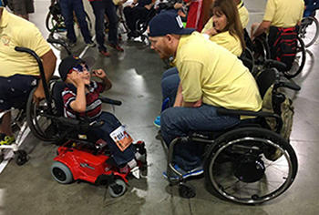Robert Fecteau talks to a child at a Kids Day event