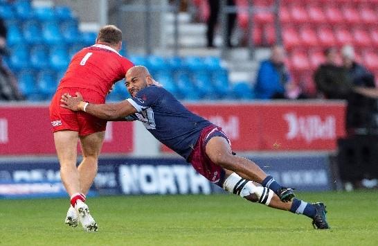A man rugby tackling someone