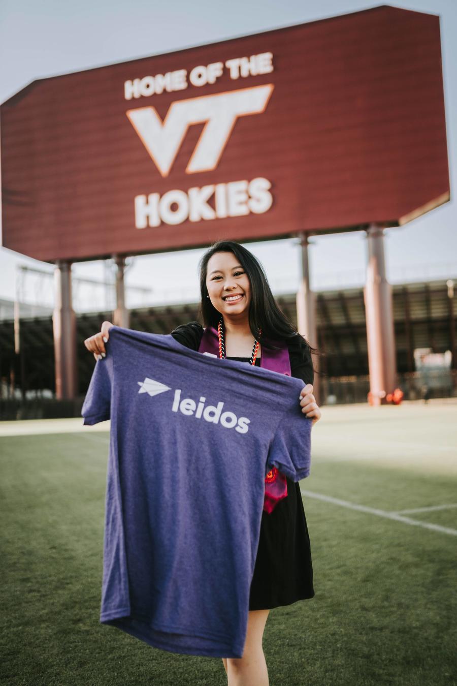 T. Van at Virginia Tech holding a Leidos t-shirt