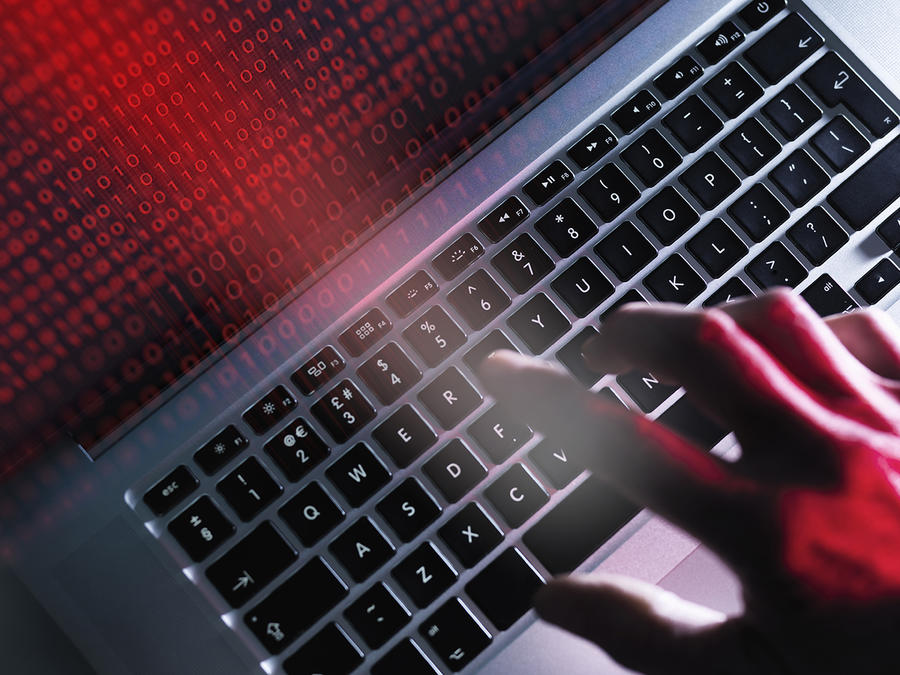 photo of a hand typing on a laptop's keyboard