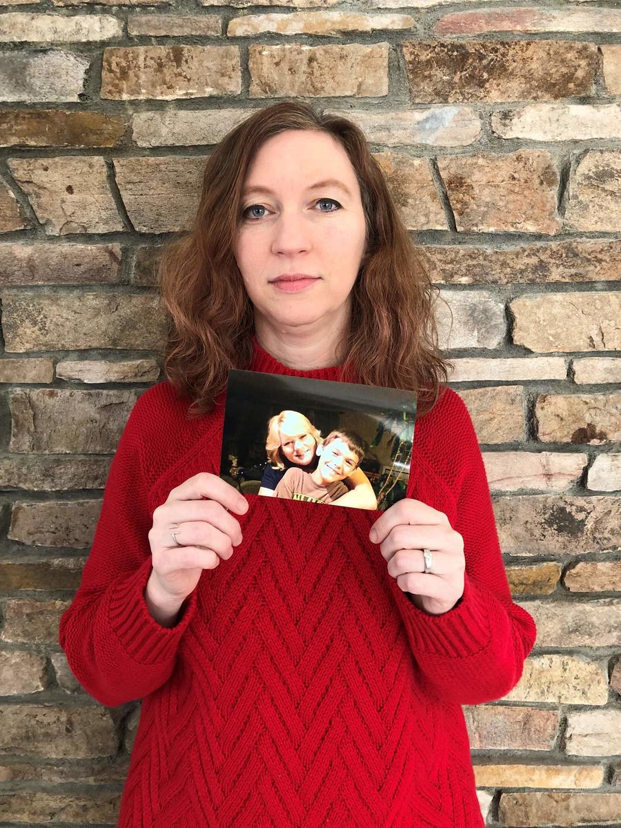 Stephanie DeGrazio holding a photo of a friend who died from a heart condition