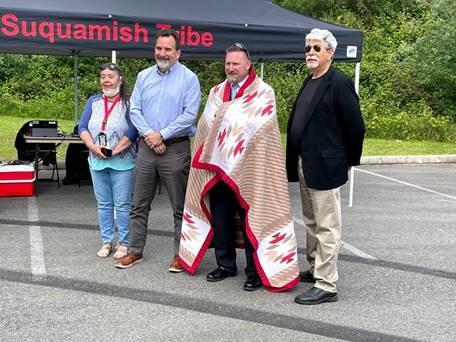 QTC VP Daniel Highland poses with Suquamish tribe members and tribal blanket