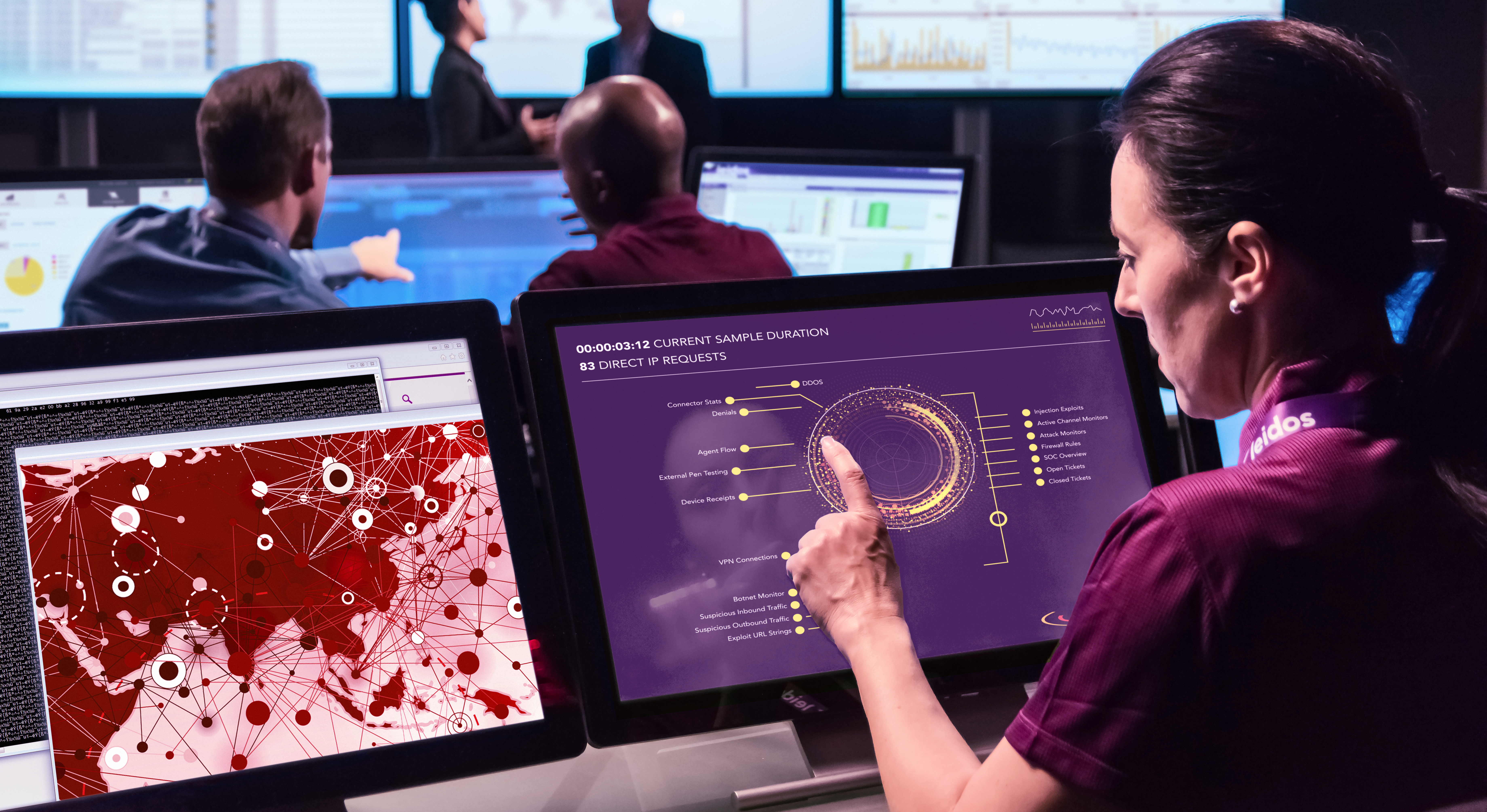 A woman with a Leidos lanyard points at a computer screen