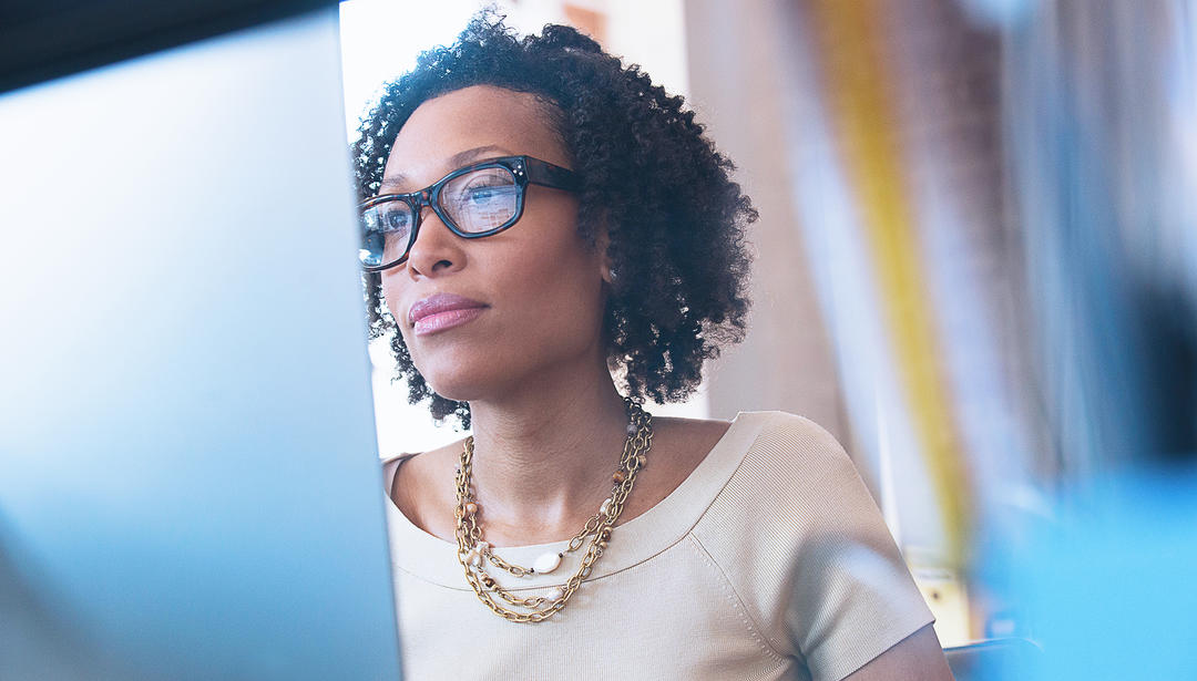 Woman wearing glasses and working on computer