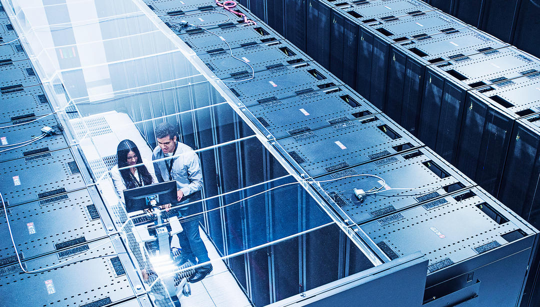 view from above, two coworkers working in server cabinets