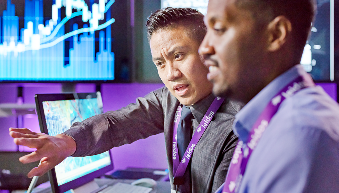 two coworkers collaborating at monitors