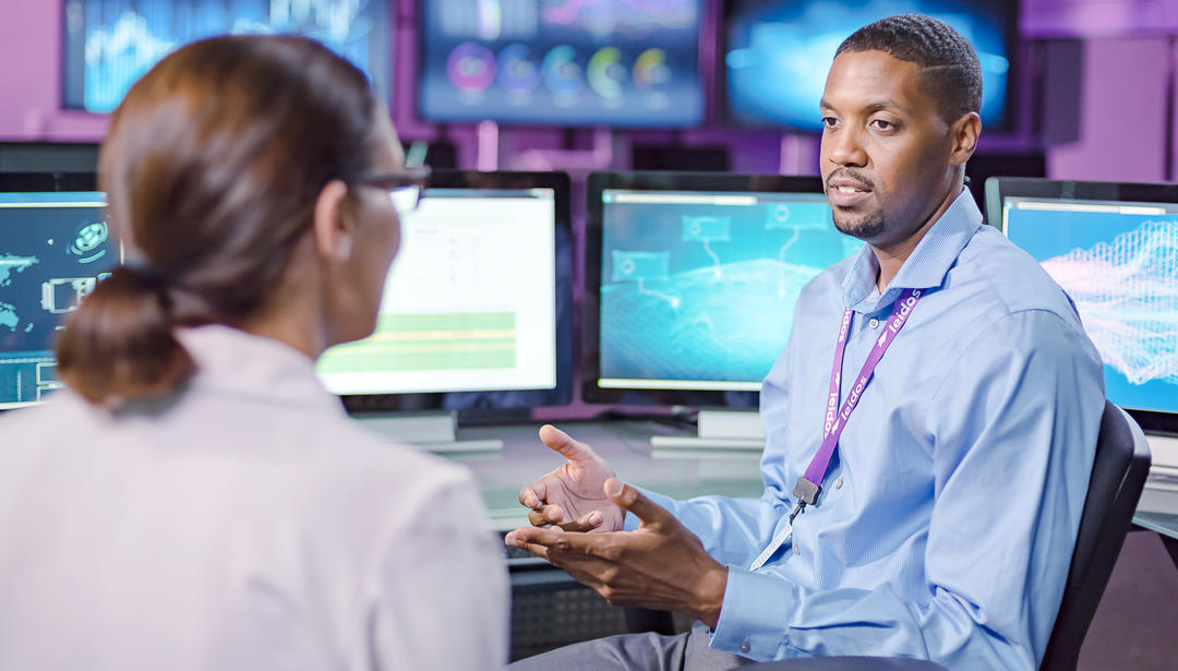 coworkers talking by computers