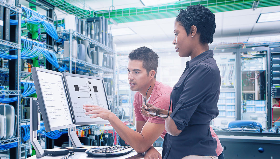 coworkers discussing and pointing at a monitor