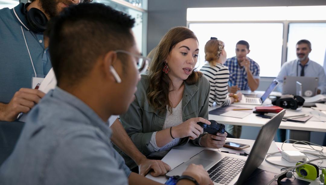 Employees working at laptop in office