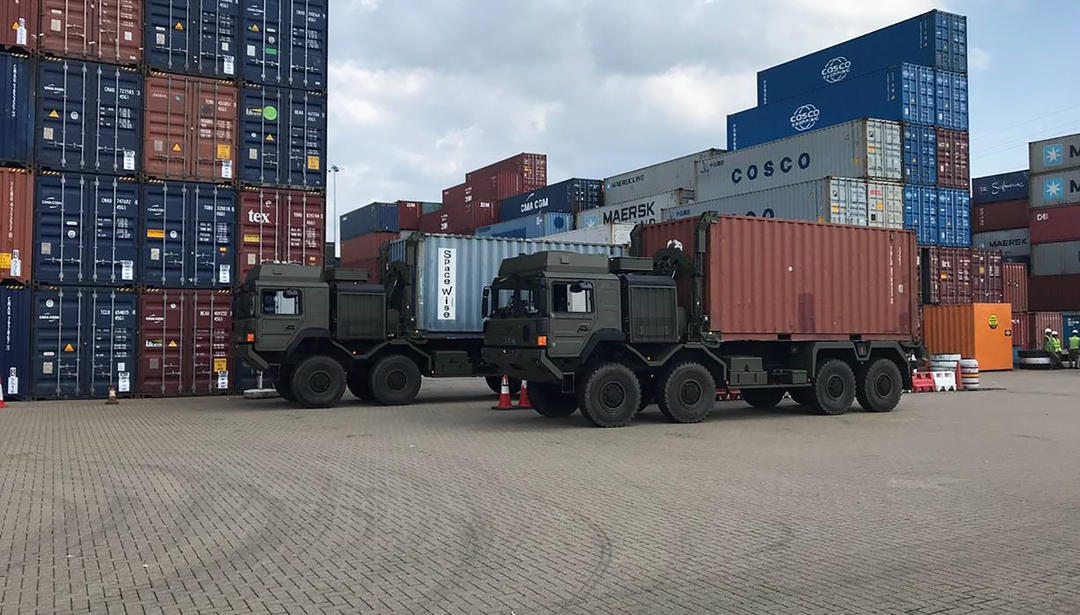 trucks in front of shipping containers