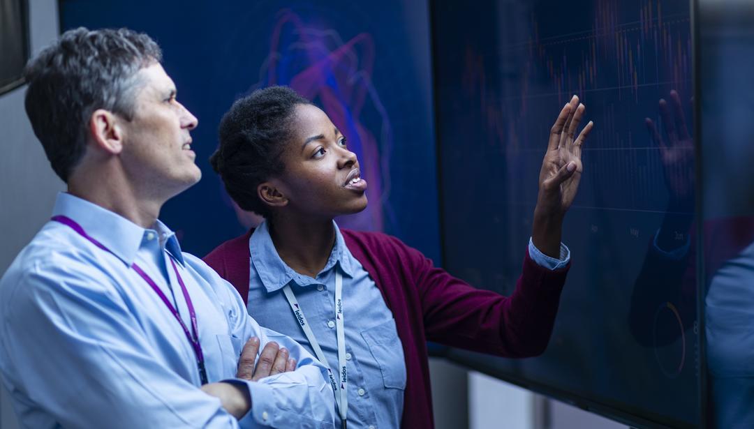 man and woman looking at dashboards