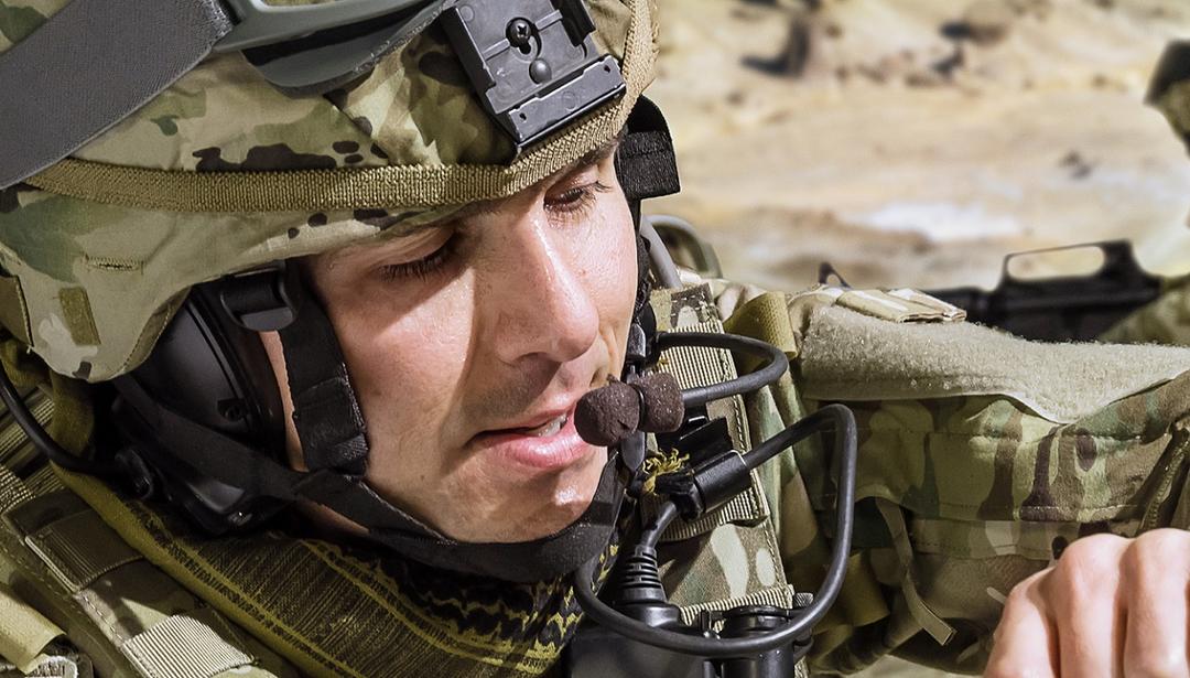 man in military uniform in the field with helmet on