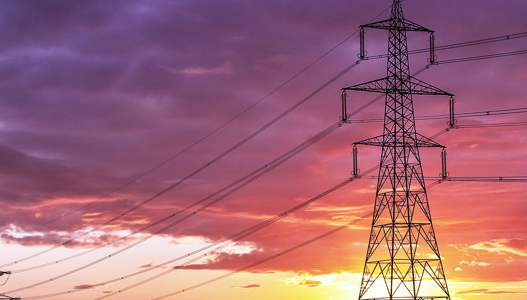 electrical tower with sunset behind it