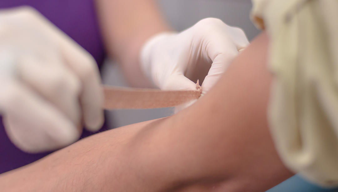 Doctor prepares to take a blood sample from military servicemember