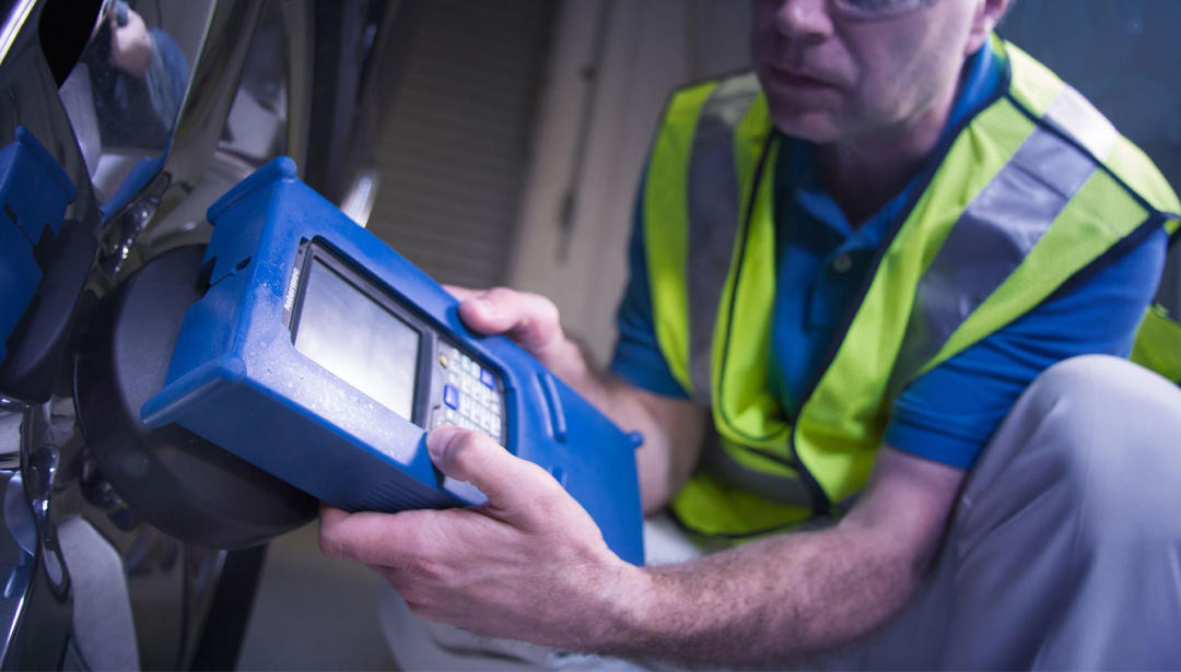 Technician using tire pressure sensor system on vehicle