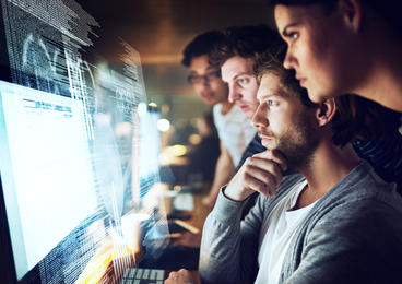 group of coworkers looking at computer monitor