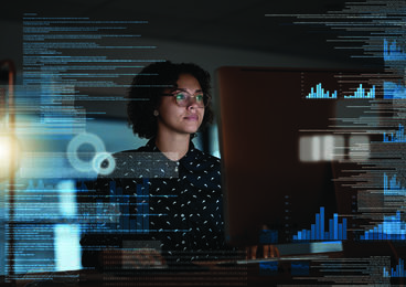 Female behind a transparent screen with text and graphs visible