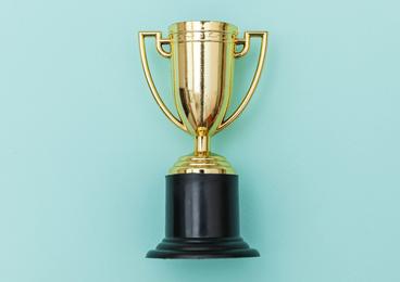A gold trophy on a light green background