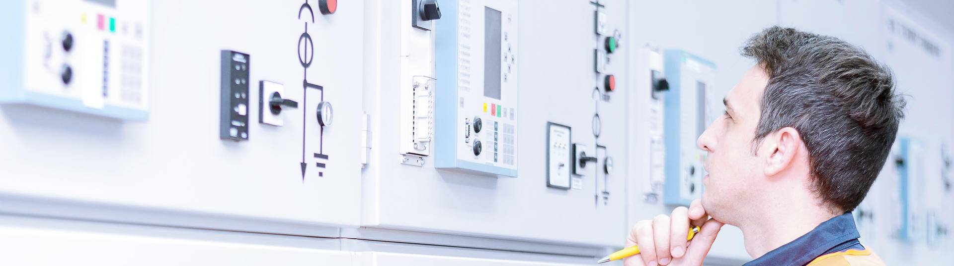 Man looking at white wall with switches