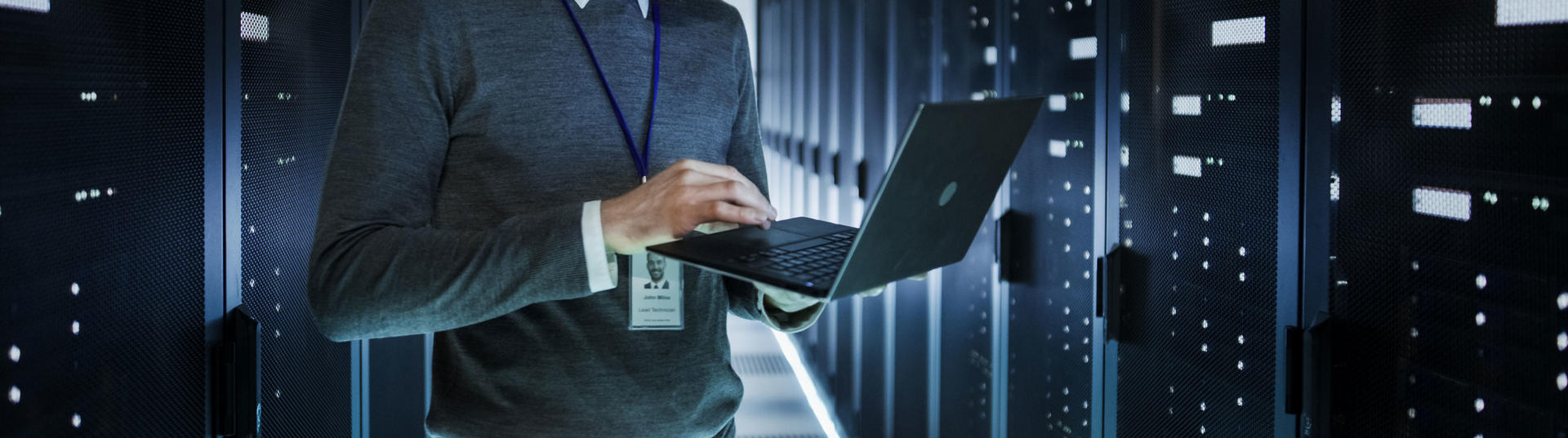 man working on laptop in a data center